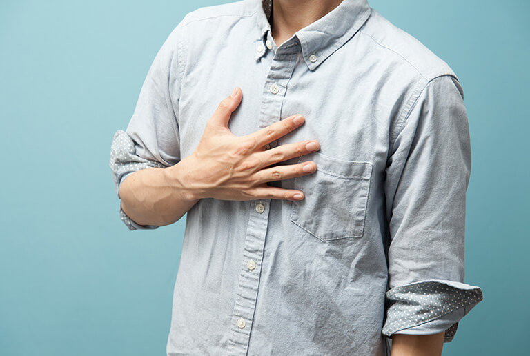 胸に手を当てる男性